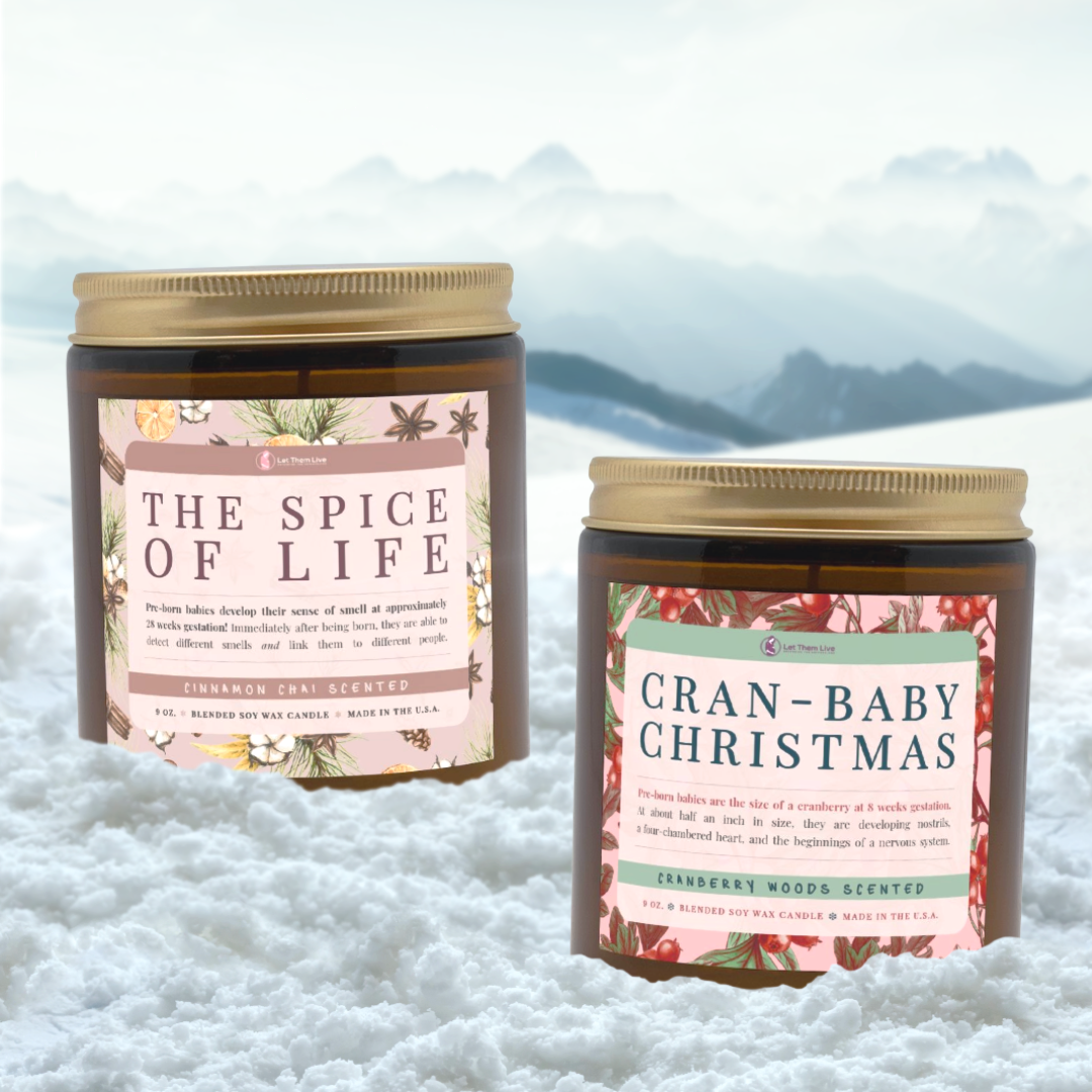 Two candles with decorative labels on a snowy background