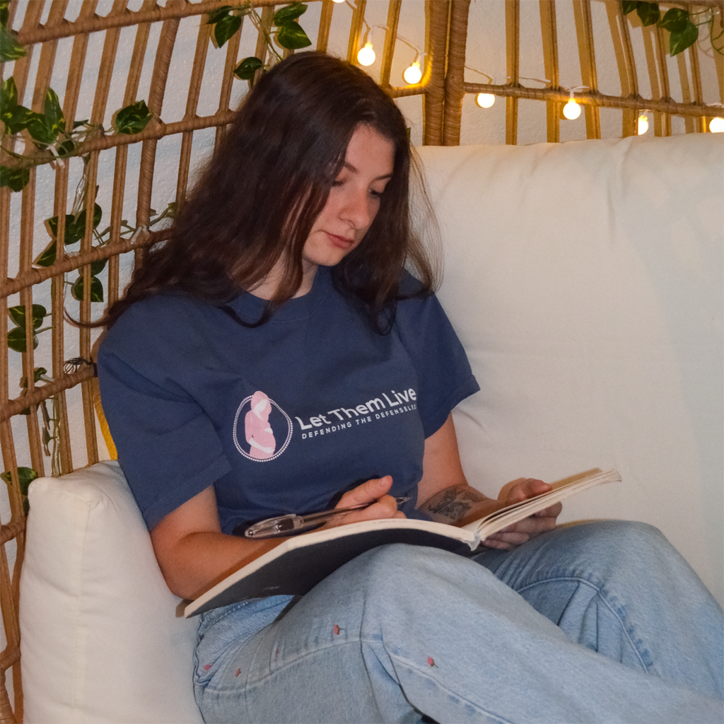 Woman reading a book on a white couch with a decorative background
