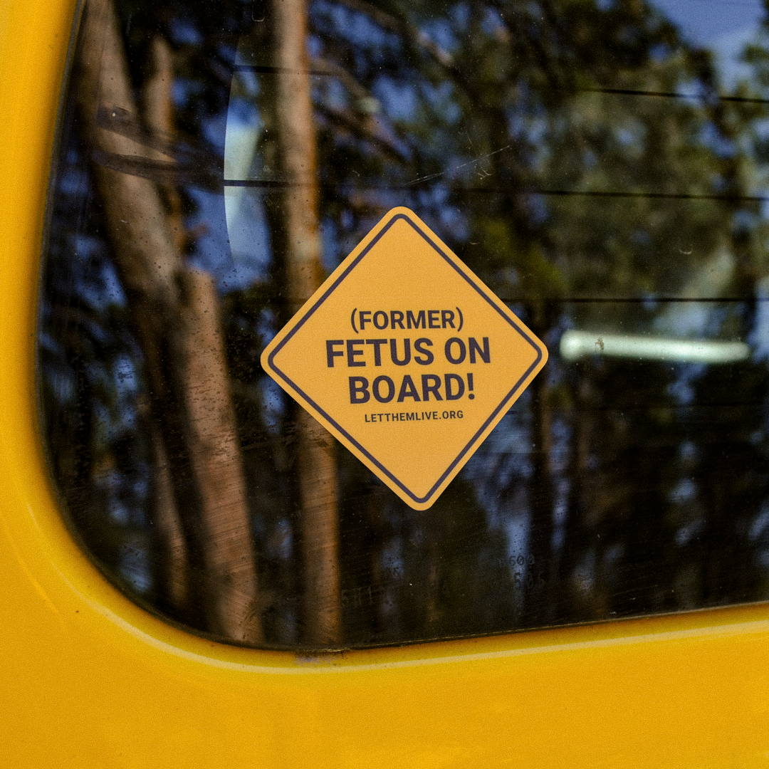 Orange pro-life sticker with the text "Former Fetus On Board" on back car window